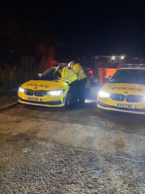 Officers with police car on the roadside