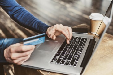 A person using a laptop to make a purchase using a credit card