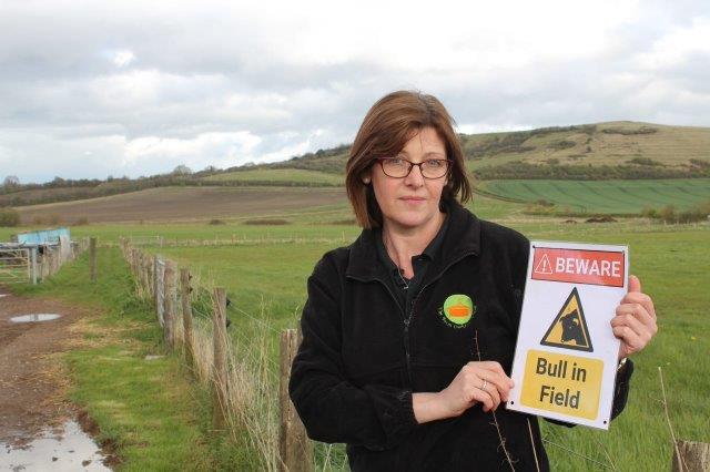 Netherstreet Farm Manager Grretchen with one of the signs that is being removed on a regular basis.