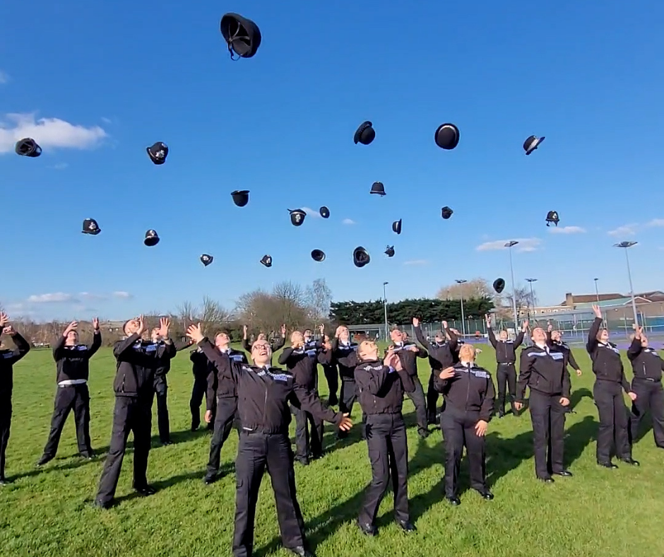 A group of police officers throwing their hats in the air