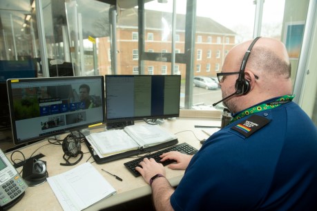 Contact Centre Operator sat at desk typing with computer in front.