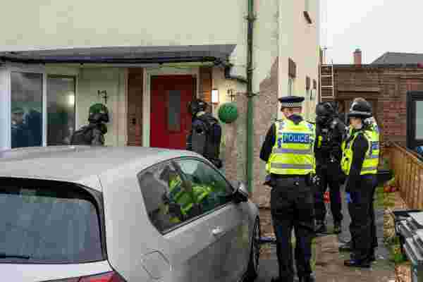 Officers outside a house carrying out a warrant