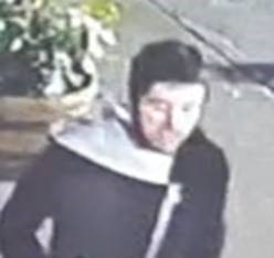 ctv image of suspect who has dark brown hair and stubble