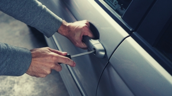 stock shot of man trying to break into car